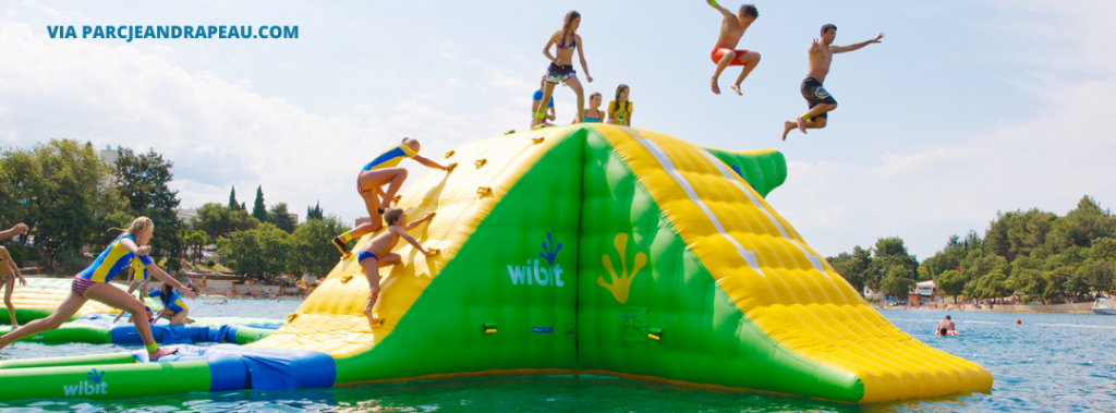people on inflatable obstacle course in water