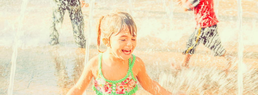 kid laughing in splash pad