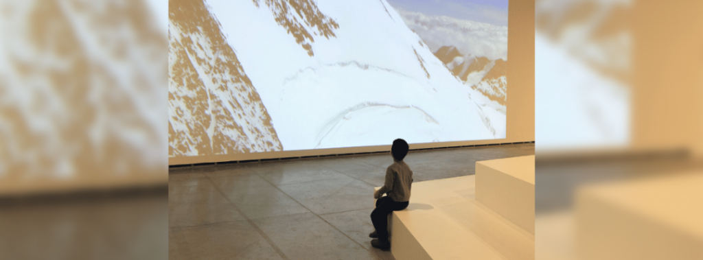 KID LOOKING AT PROJECTION OF MOUNTAIN AT MUSEUM