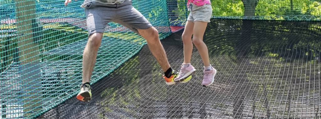 dad and kid jumping on trampoline
